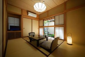 uma sala de estar com uma mesa, um sofá e uma televisão em Shouhakutei Azumaso em Tendo