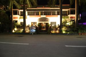 um edifício com a porta da frente iluminada à noite em Hotel Shivam em Pune