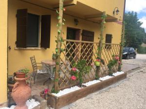 eine Veranda eines Hauses mit einem Tisch und einem Zaun in der Unterkunft Agriturismo Fattoria del Colle in Iesi