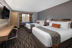 um quarto de hotel com duas camas e uma televisão de ecrã plano em Microtel Inn & Suites by Wyndham Florence em Florence