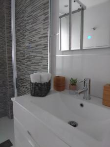 uma casa de banho com um lavatório branco e um espelho. em City Comfort em Estepona