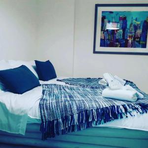 sypialnia z łóżkiem z niebieskimi poduszkami i telefonem w obiekcie MiKlod Apartments w mieście Palermo
