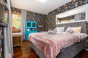 a bedroom with a large bed with floral wallpaper at Villa Aia Studio in Pärnu