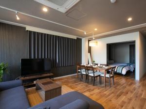 - un salon avec un canapé, une table et un lit dans l'établissement BIG ROOM GUEST HOUSE, à Osaka