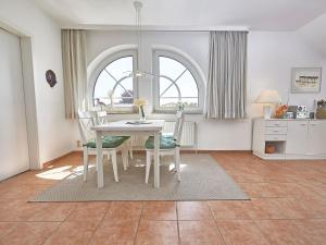 ein Esszimmer mit einem weißen Tisch und Stühlen in der Unterkunft Haus Granitzblick - Apt. 18 in Ostseebad Sellin