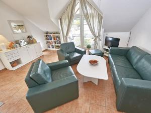 ein Wohnzimmer mit einem Sofa, Stühlen und einem Tisch in der Unterkunft Haus Granitzblick - Apt. 18 in Ostseebad Sellin