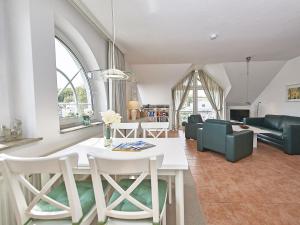 ein Wohnzimmer mit einem weißen Tisch und Stühlen in der Unterkunft Haus Granitzblick - Apt. 18 in Ostseebad Sellin