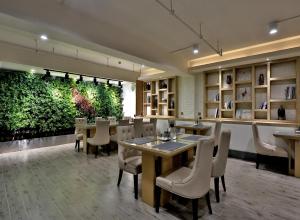 a restaurant with tables and chairs and a green wall at Byland Star Hotel in Yiwu