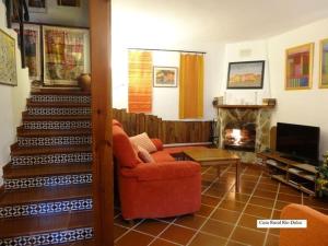 a living room with a red chair and a fireplace at Spa y Casa Rural Rio Dulce in Aragosa