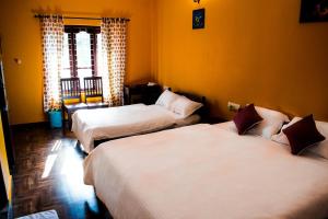 three beds in a room with yellow walls at Sharanyam Homestay in Mananthavady