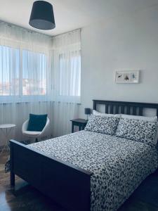 a bedroom with a bed and a chair and windows at B&B La Terrazza Near The Beach in Bari