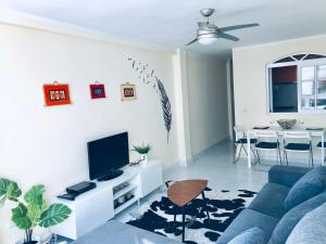 un salon avec un canapé bleu et une télévision dans l'établissement Beautiful modern apartment 100m from the sea, à Fuengirola