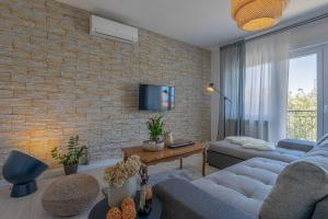 a living room with a couch and a brick wall at Premium 100m2 sea view apartment in Ližnjan