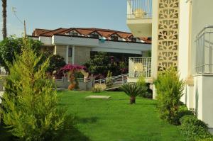 a house with a yard with green grass and trees at THe NORDİC HOTEL in Kemer