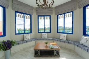 a living room with windows and a table at Costa Village Bangsaray in Bang Sare +150 photos