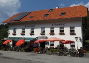 a white building with red umbrellas in front of it at Zehrermühle Campinghütte in Schönberg