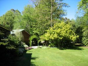 a yard with green grass and trees and a house at RiverCottage-selfcontained in Marysville