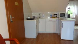 a kitchen with white cabinets and a microwave at U pani Ani Żeglarska 18 in Augustów