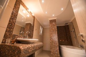 a bathroom with a sink and a tub and a mirror at Vicky Rooms in Paralia Dionysiou +88 photos