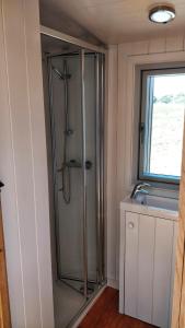 a glass shower in a bathroom with a window at The Wheelhouse in Bude