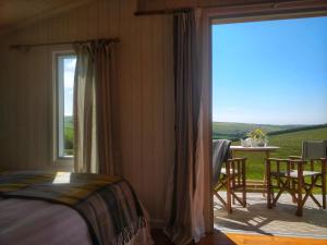 a bedroom with a bed and a balcony with a table at The Wheelhouse in Bude