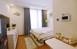 a small bedroom with a bed and a television at A Cosy Apartment in Vinhomes Green Bay Ha Noi in Hanoi