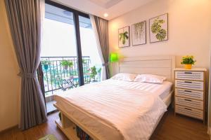 a bedroom with a bed and a large window at A Cosy Apartment in Vinhomes Green Bay Ha Noi in Hanoi +55 photos