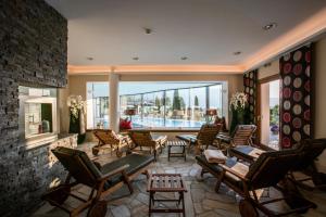 a room with chairs and tables and a large window at Sport-Wellnesshotel Bichlhof in Kitzbühel