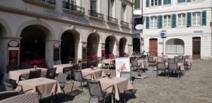 a restaurant with tables, chairs, tables and umbrellas at Hostellerie du XVI Siècle in Nyon