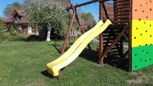 uno scivolo su un parco giochi in un cortile di Spāres a Pāvilosta