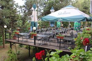 a row of tables with an umbrella and potted plants at Park Hotel Briz - All Inclusive & Free Parking in Golden Sands