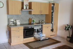 a kitchen with a stove and a dishwasher at Ferienwohnung Inga in Spabrücken