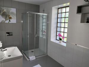 a bathroom with a glass shower and a sink at Willa Kormoran in Augustów +24 photos