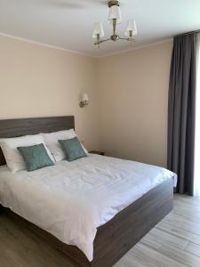 a bedroom with a large white bed with two pillows at Willa Kormoran in Augustów