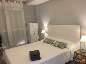 エル・メダノにあるApartamento Idealのベッドルーム1室(白いベッド1台、タオル2枚付)