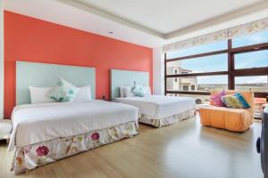馬公市的住宿－海之徑民宿，橙色墙壁客房的两张床