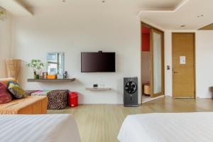 馬公市的住宿－海之徑民宿，客厅配有沙发和墙上的电视