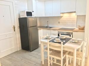 a kitchen with a table with chairs and a refrigerator at Apartamento Ideal in El Médano