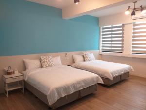 una camera da letto con due letti e una finestra di Next door of No 7 Youheng B&B a Città di Hualien