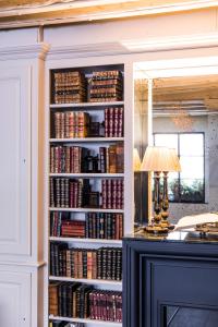 a book shelf filled with books next to a desk at Hotel Verneuil Saint Germain in Paris
