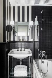 a bathroom with a sink and a shower and a mirror at Hotel Verneuil Saint Germain in Paris