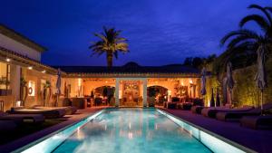 a villa with a swimming pool at night at Le Pre de la Mer in Saint-Tropez