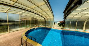 an indoor swimming pool in a building with a building at Apartments Four Leaf Clover Bansko to rent in Bansko