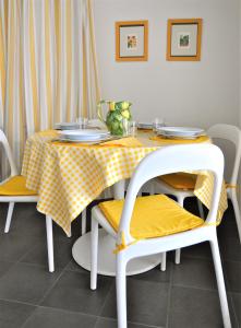 einen Esstisch mit einem gelben und weißen Tischtuch in der Unterkunft La Palma vacanze in riva al mare in Diano Marina