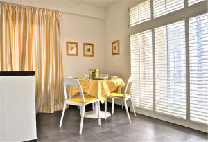 ein Esszimmer mit Tisch und Stühlen und Fenstern in der Unterkunft La Palma vacanze in riva al mare in Diano Marina + 10 Fotos