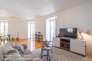 uma sala de estar com um sofá e uma televisão de ecrã plano em Akicity Lisboa Pearl em Lisboa