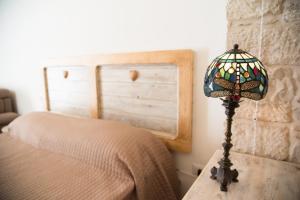 una lámpara sentada en una mesa junto a una cama en Piazza Duomo - Medieval Puglia's House, en Giovinazzo