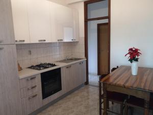 a kitchen with a stove and a wooden table at Apartment Bella Costa I in Kaštela