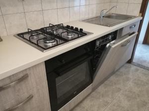 a stove top oven in a kitchen next to a sink at Apartment Bella Costa I in Kaštela