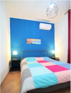 a bedroom with a bed with a blue wall at La dimora di Nonno Nuccio in Ragusa